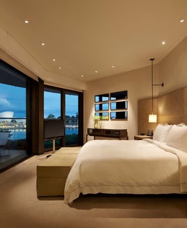 hotel room with wrap-around windows with views of the Sydney Opera house