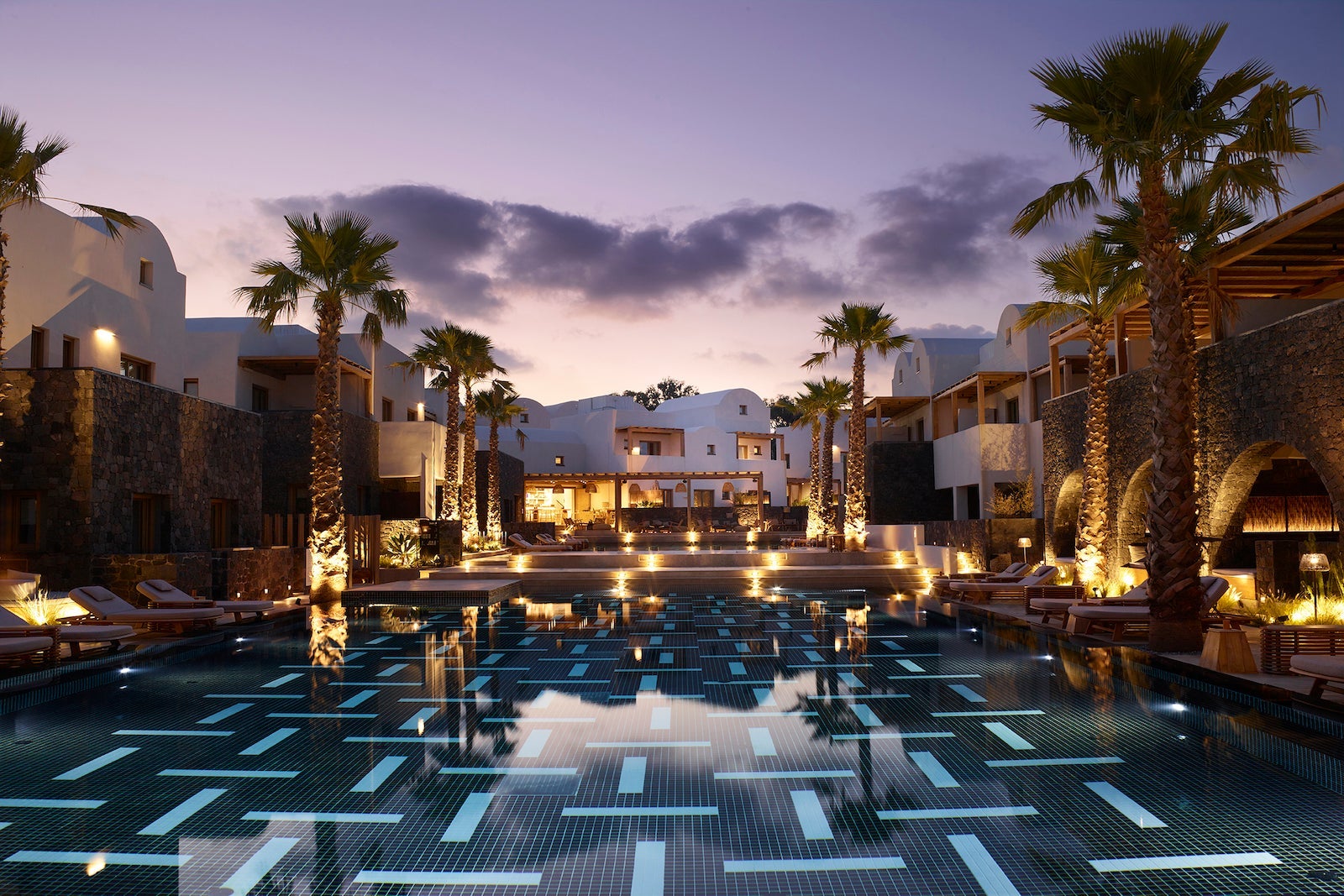 pool surrounded by buildings at dusk