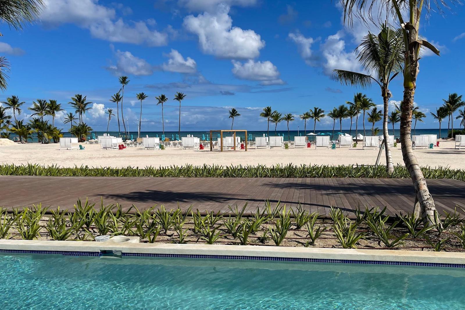 view of beach with palm trees from the pool