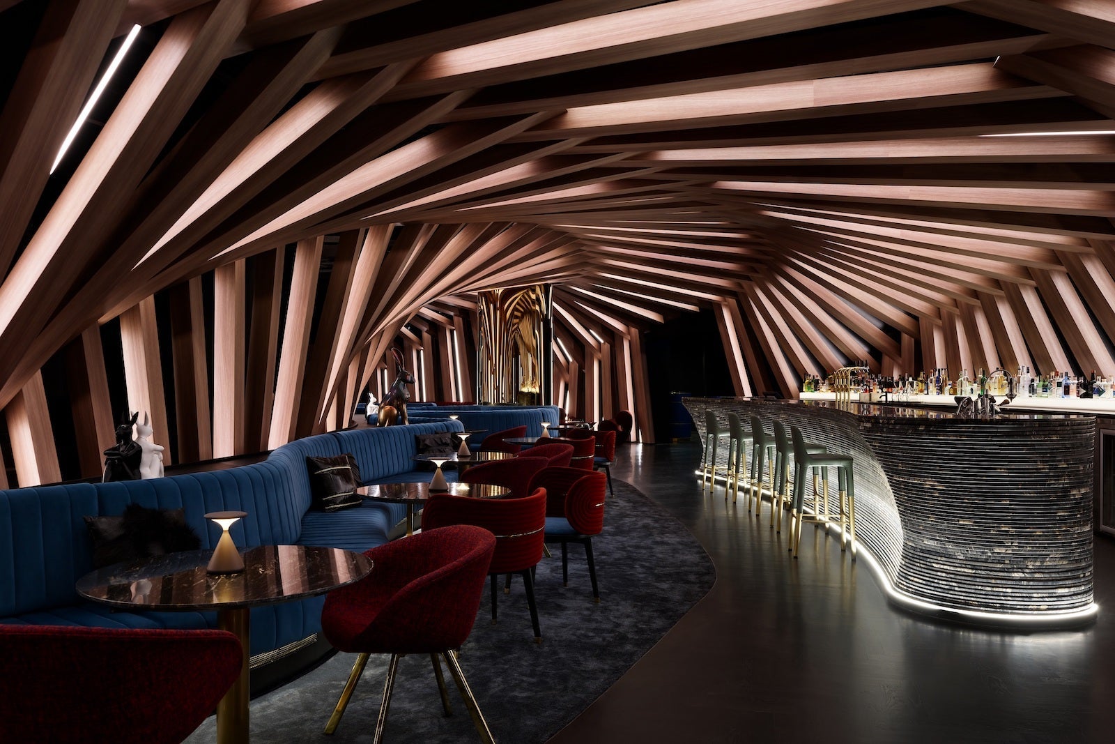 modern restaurant with dark floors, tables with red velvet chairs and light-up ceiling