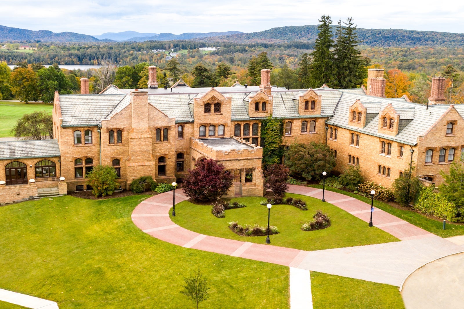 exterior photo of large mansion and green courtyard