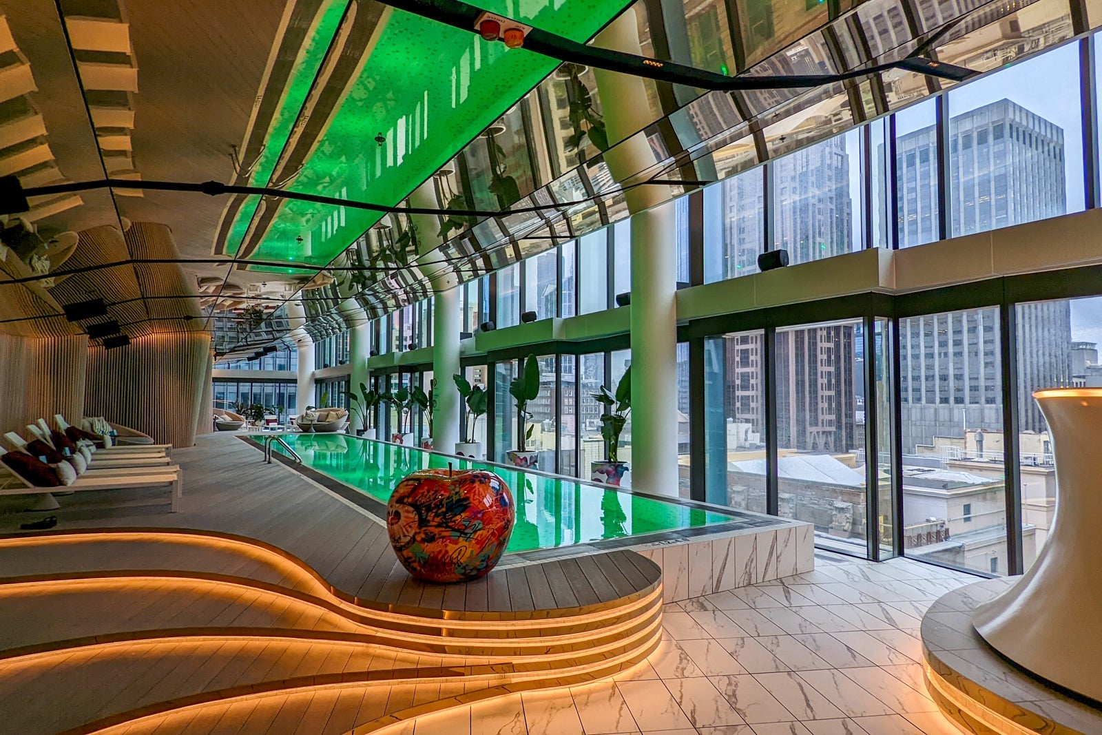 green lights in a hotel swimming pool reflect onto the glass dome around it