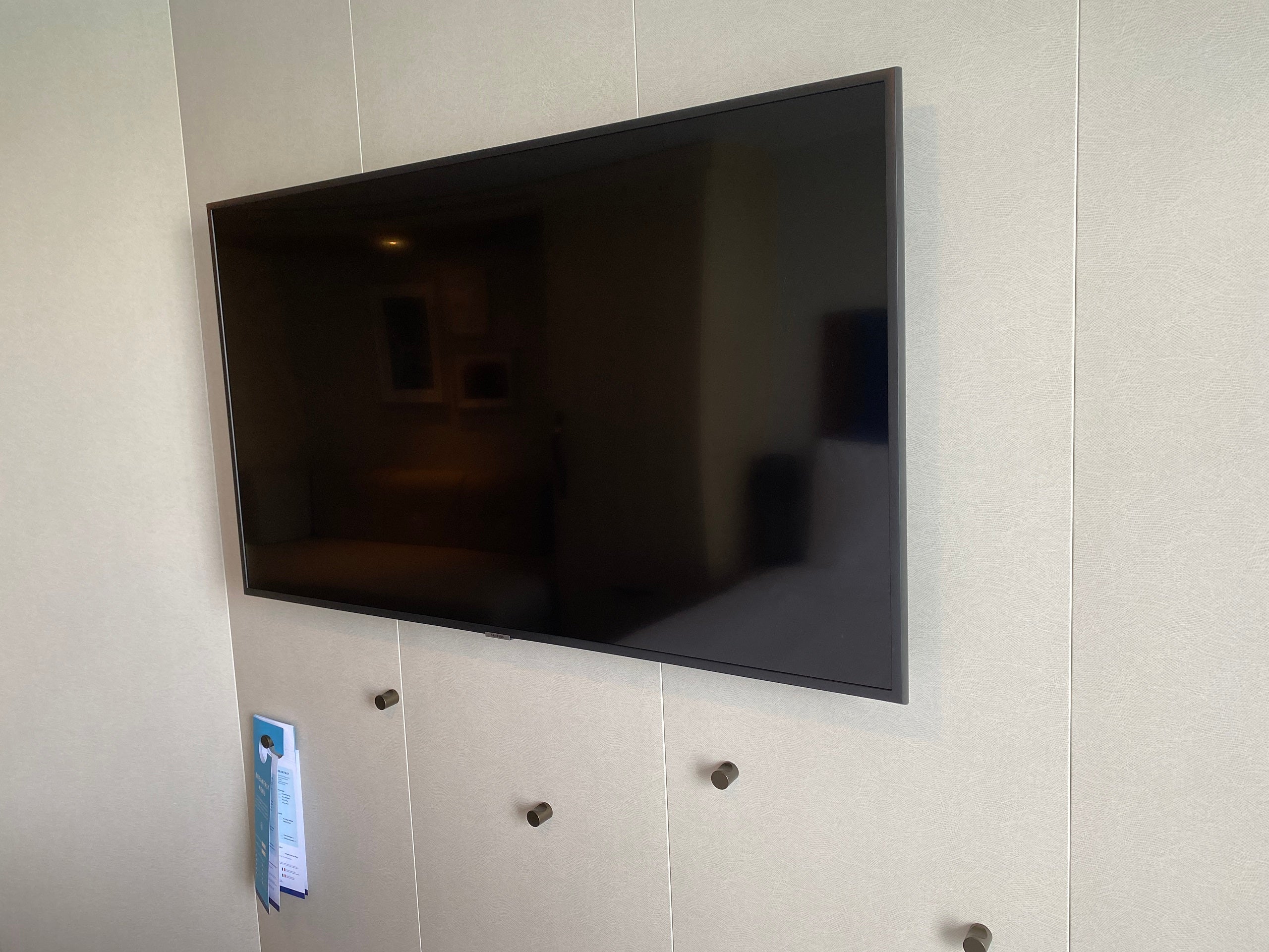 TV and hanging pegs in a balcony cabin on Royal Caribbean's Wonder of the Seas.