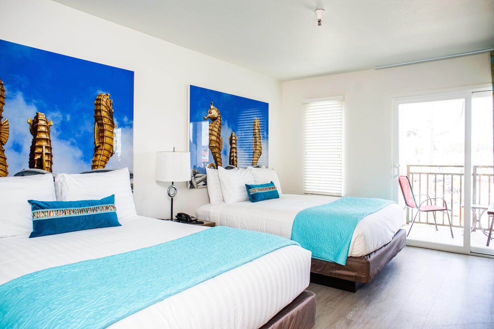 Hotel bedroom with large beach photos behind the bed