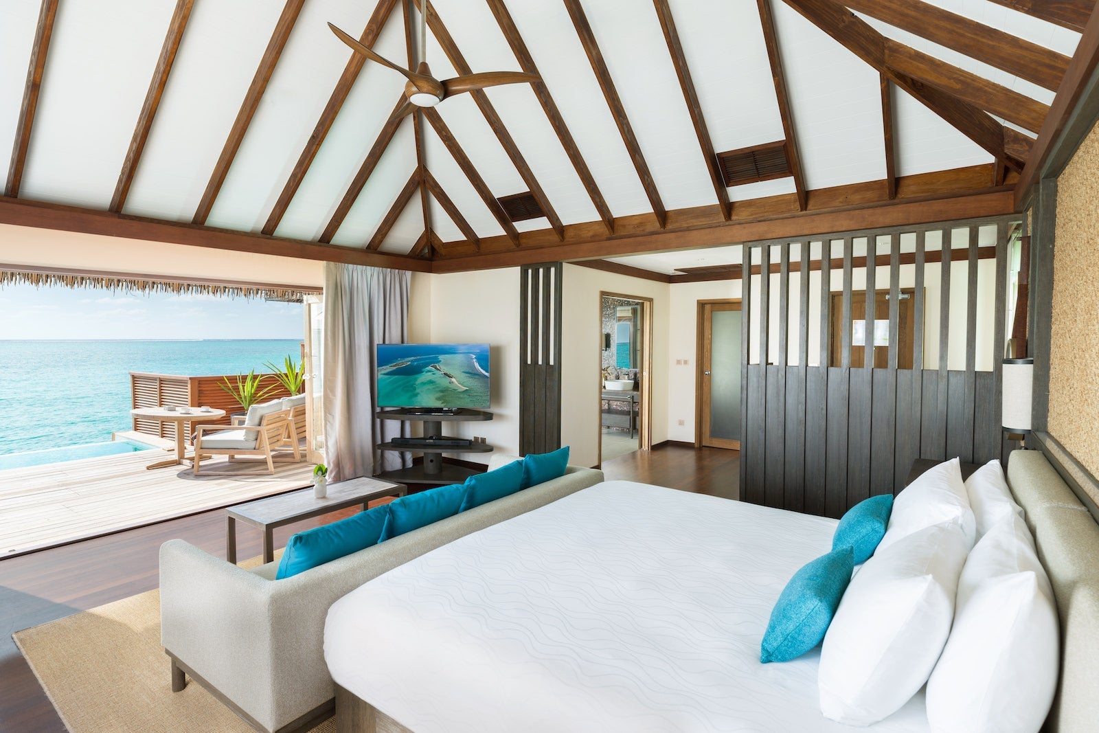 hotel room with open wall and deck overlooking ocean