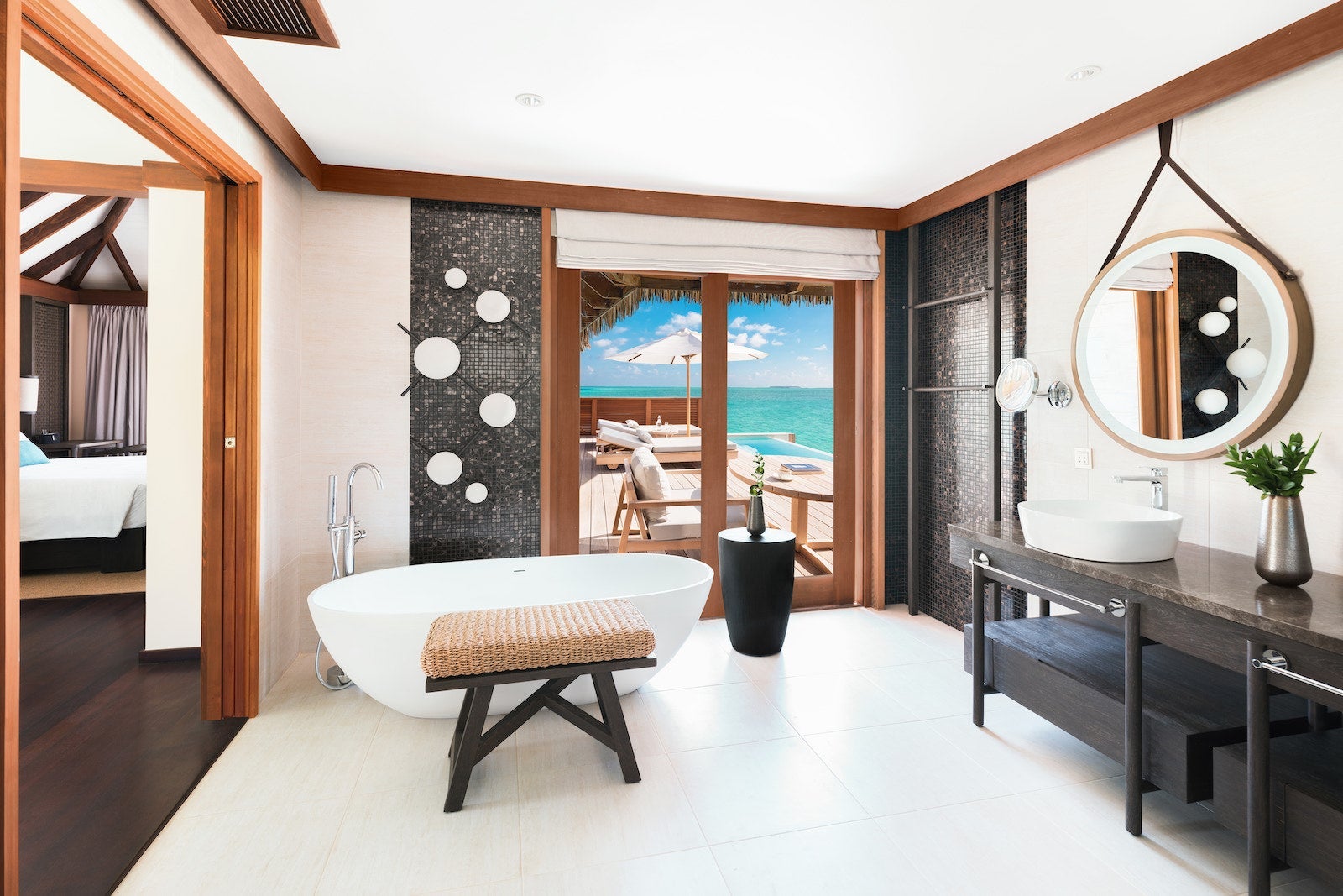 bathtub in bathroom looking out at deck of overwater villa