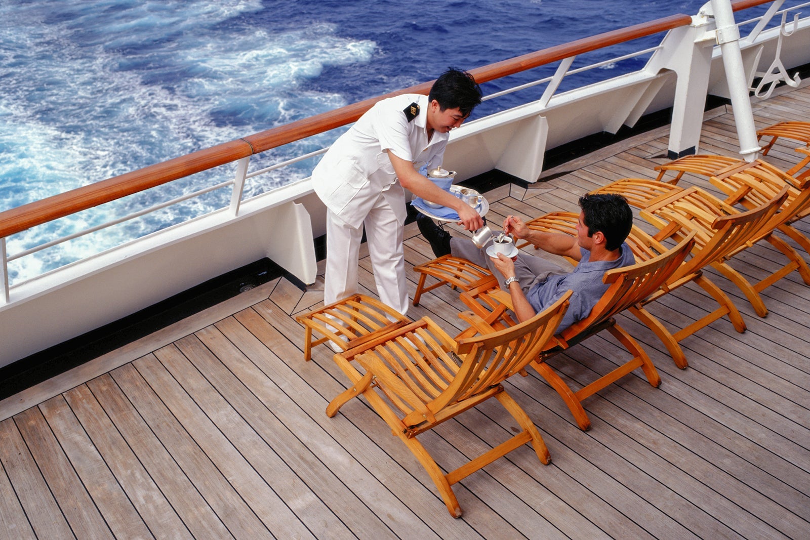 Server refills coffee on cruise deck