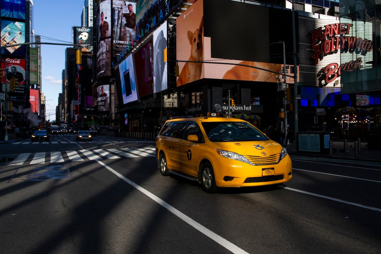 A taxi drives through Times Square on November 16, 2020 in New York, NYC bill is looking to put Uber and yellow Cabs on single app platform where riders order from the app any for-hire vehicle, including taxis and cars of Uber or Lyft.