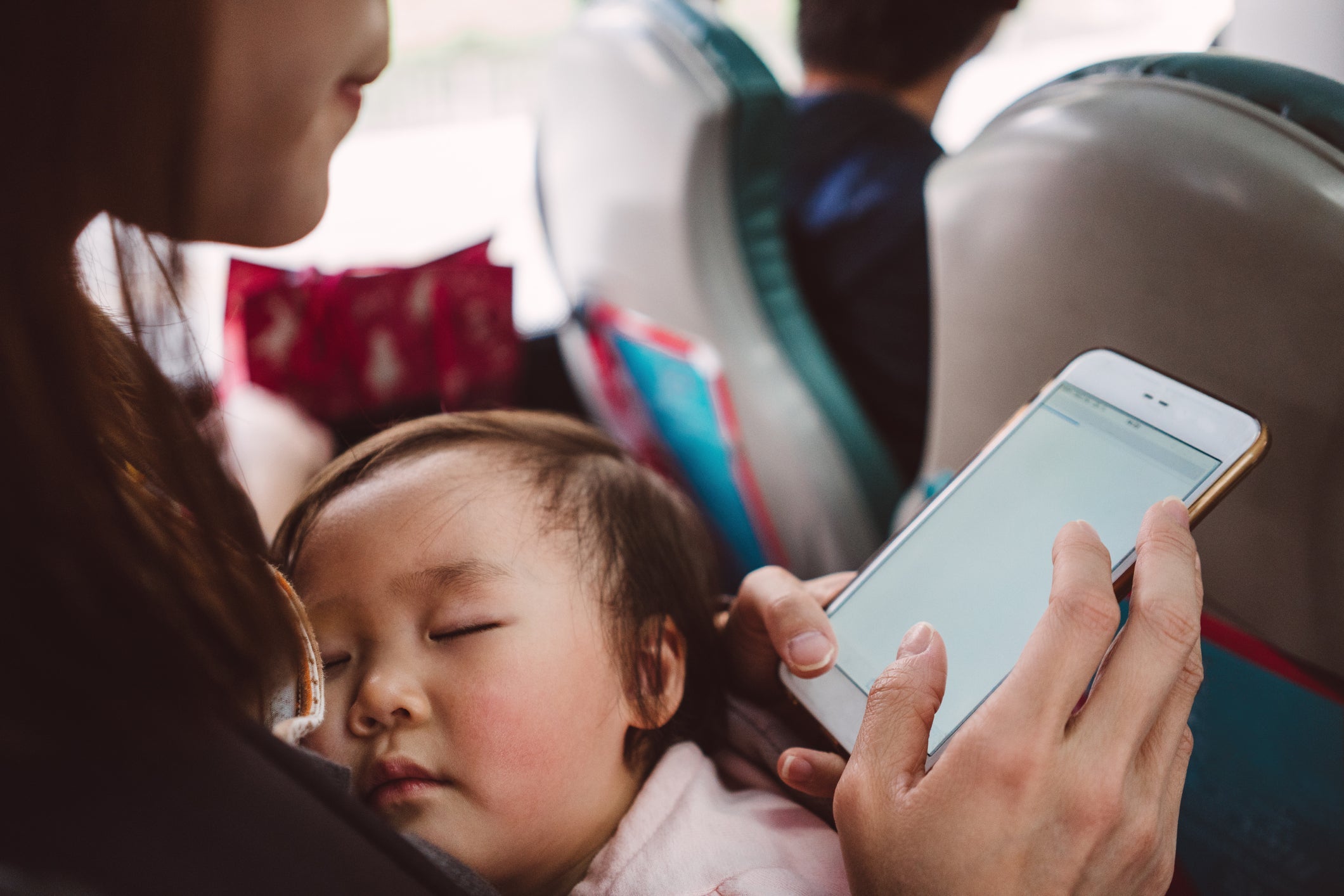 Baby sleeps on mom's lap during plane ride