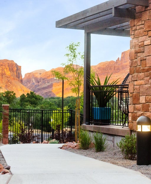 concrete pathway around stone building with mountains in the distance