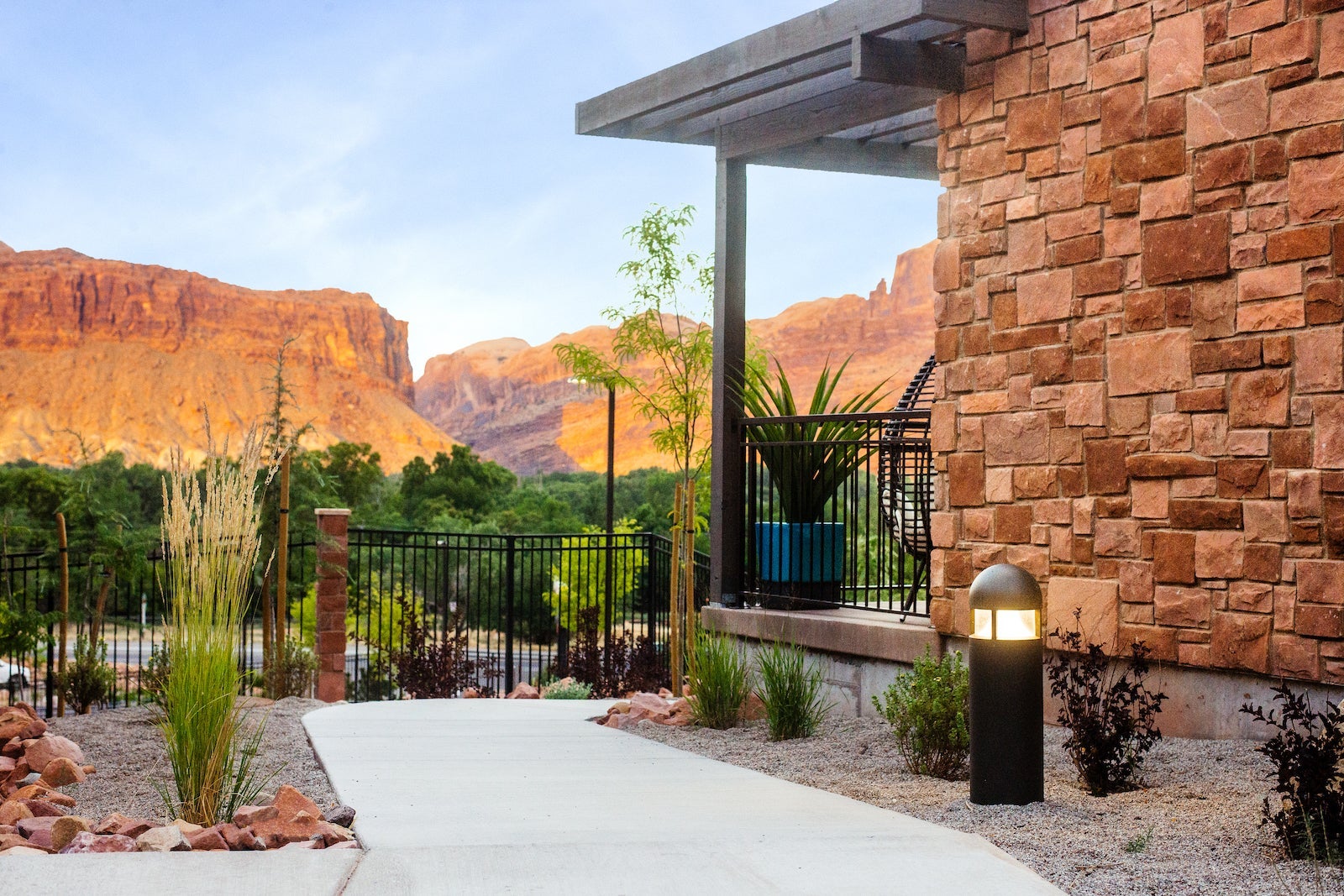 concrete pathway around stone building with mountains in the distance
