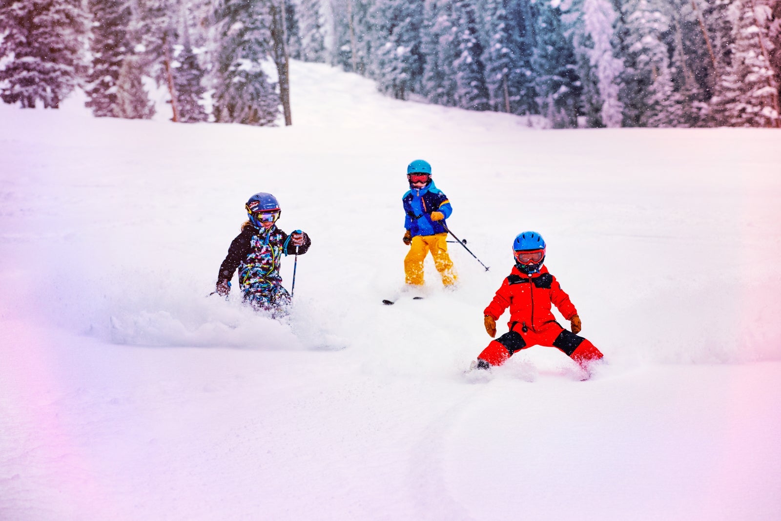 Three children skiing down a mountain.