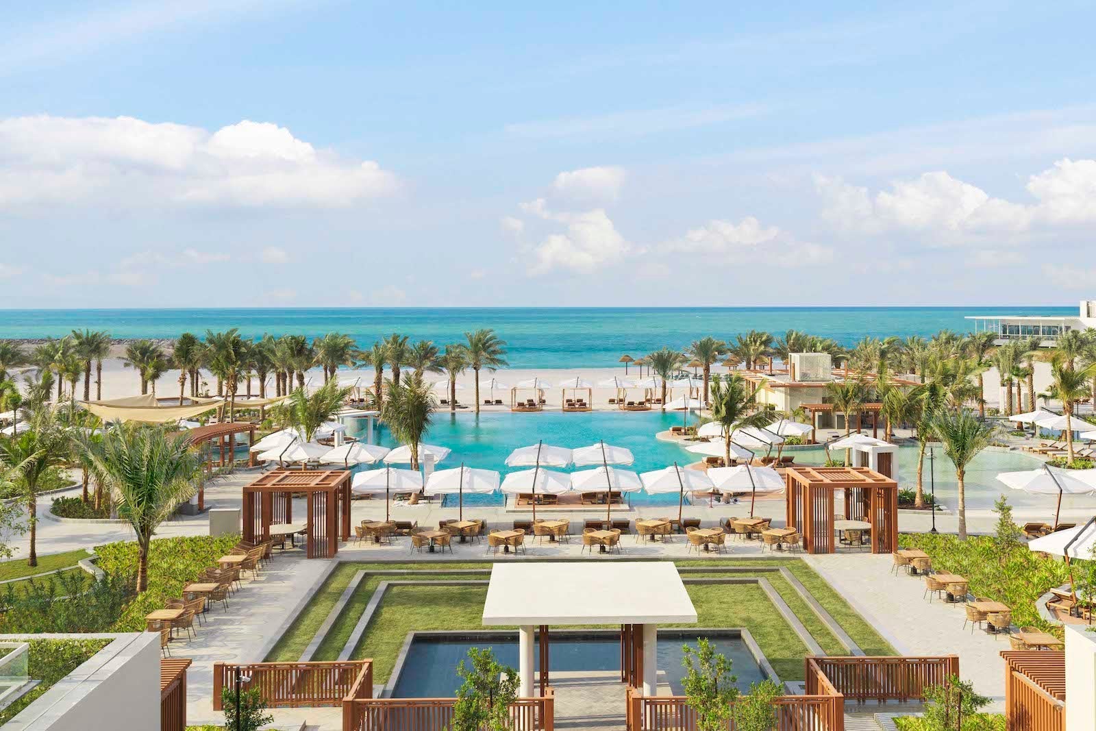 view of pool, beach and palm tress