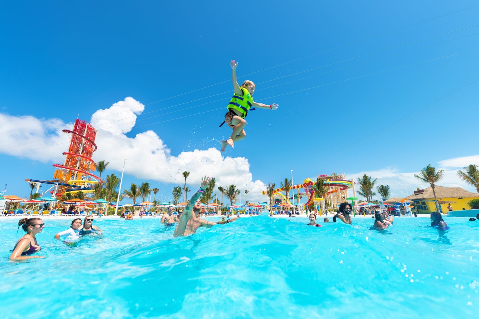 Dad throwing son in the air in wave pool at Royal Caribbean's private island