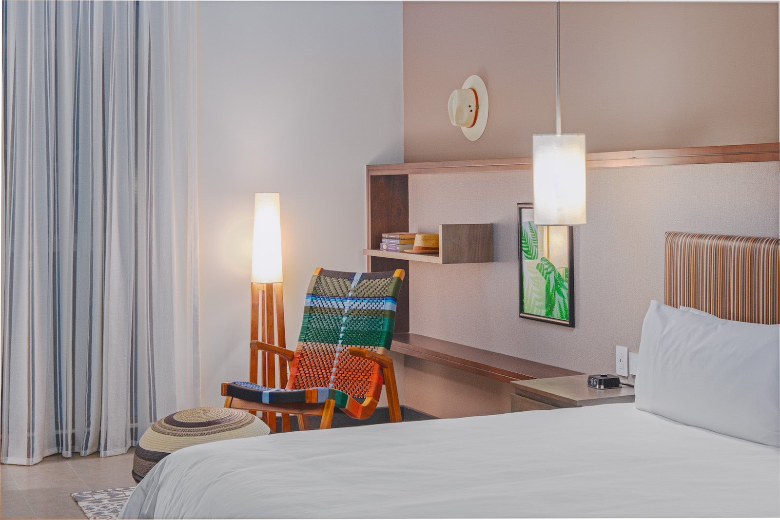 hotel room with wall board, chair and lamp