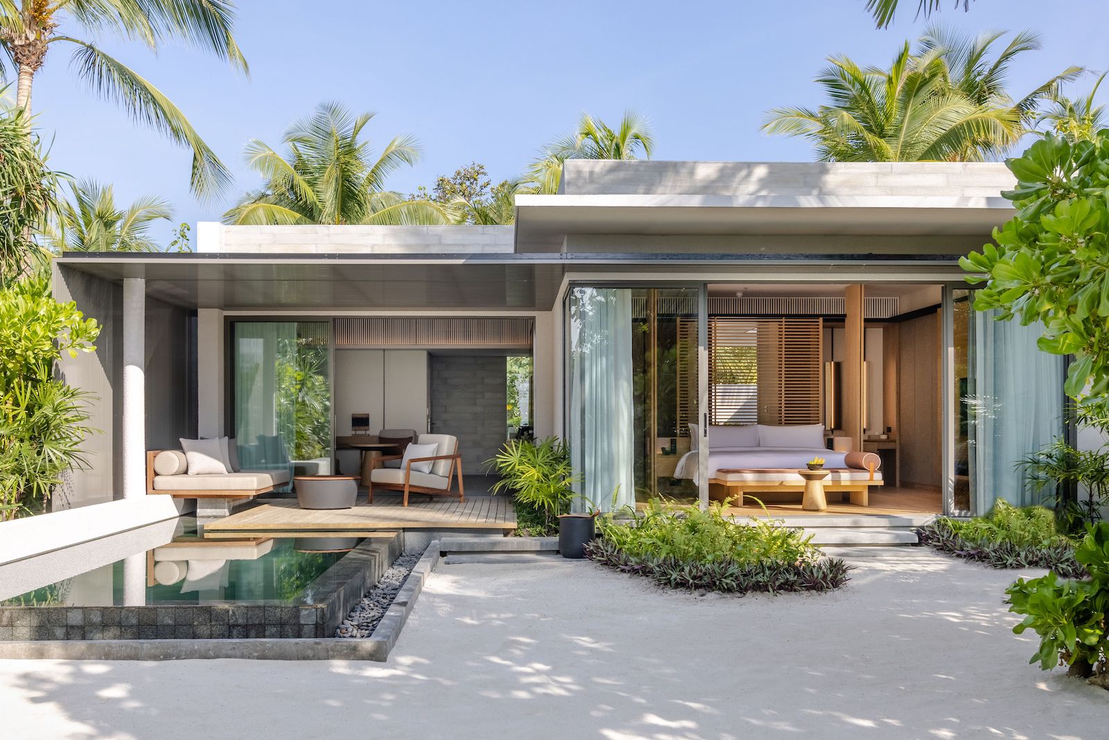 beach villa with plunge pool, seating area and bed