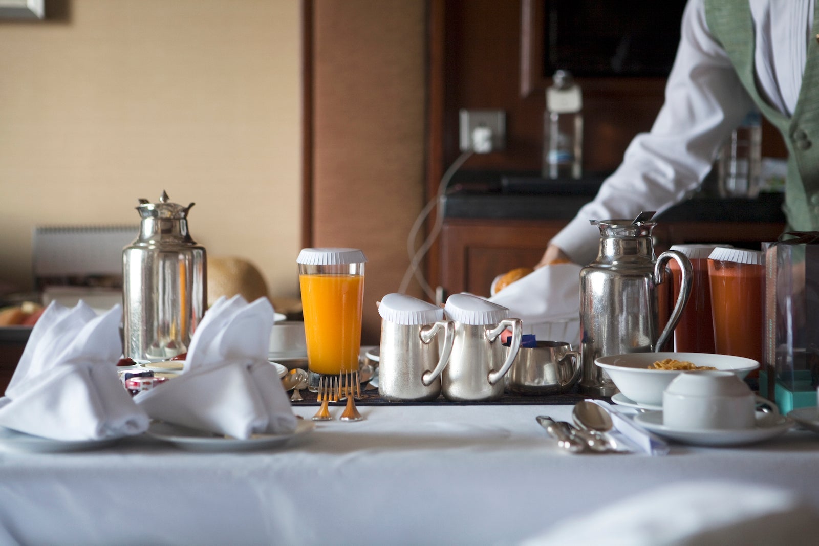 person delivering room service on a cart to hotel room