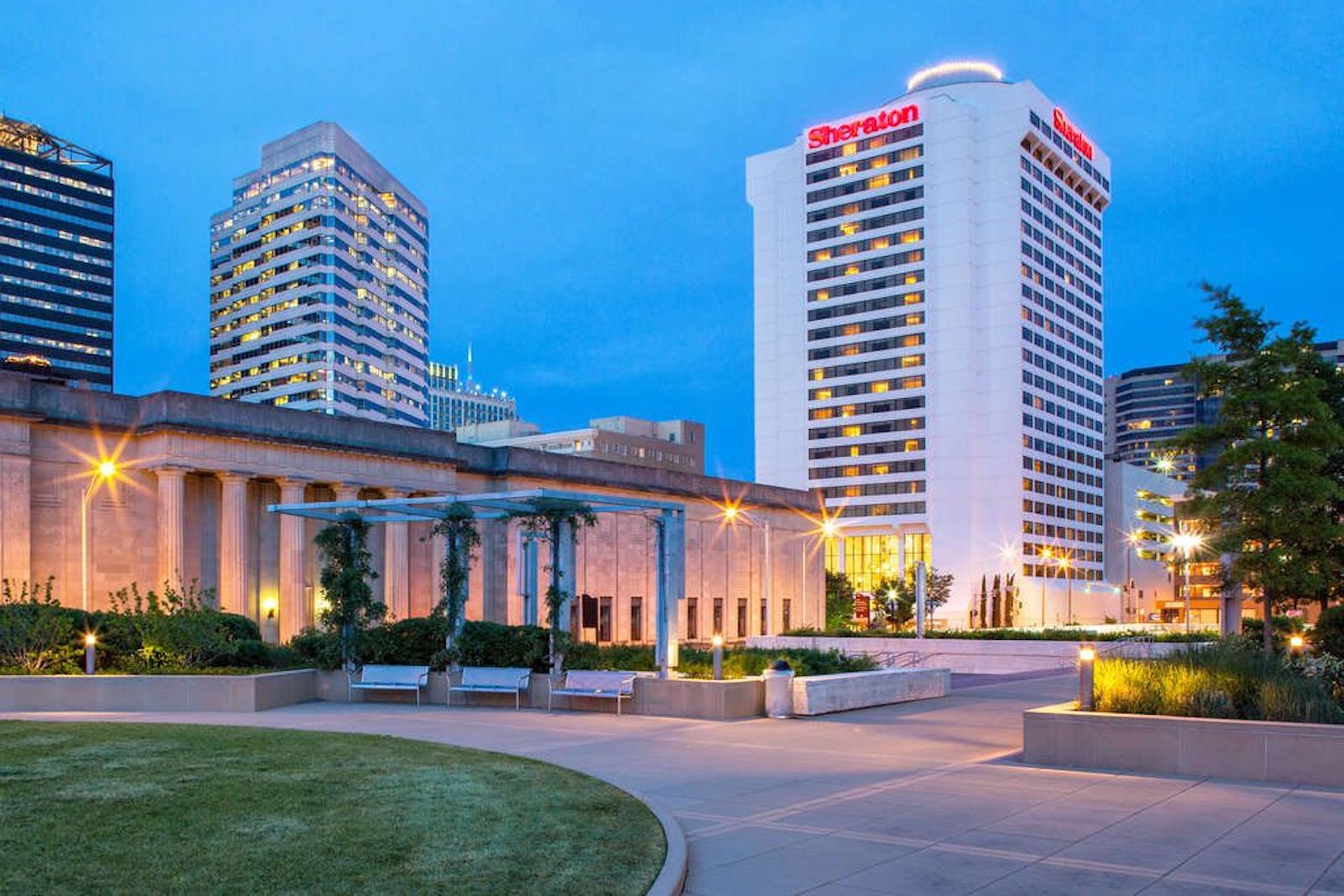 large white hotel building at night behind park