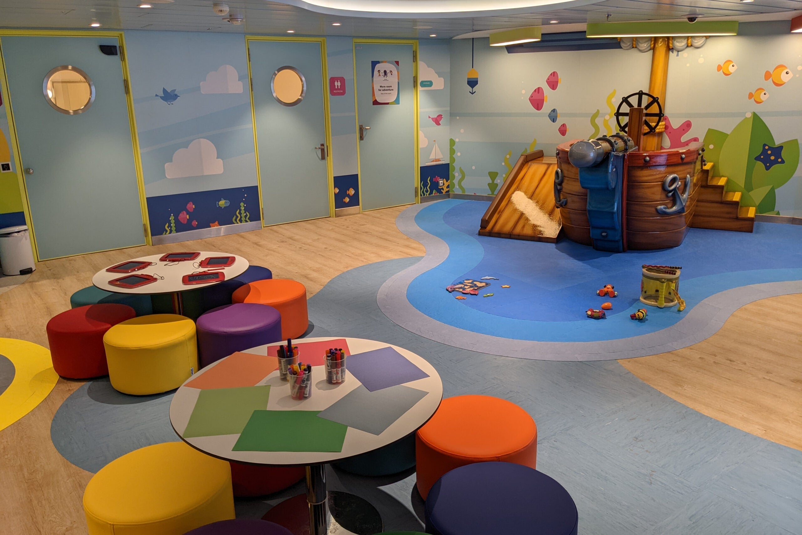 Colorful kids play area with tables and pirate ship play structure