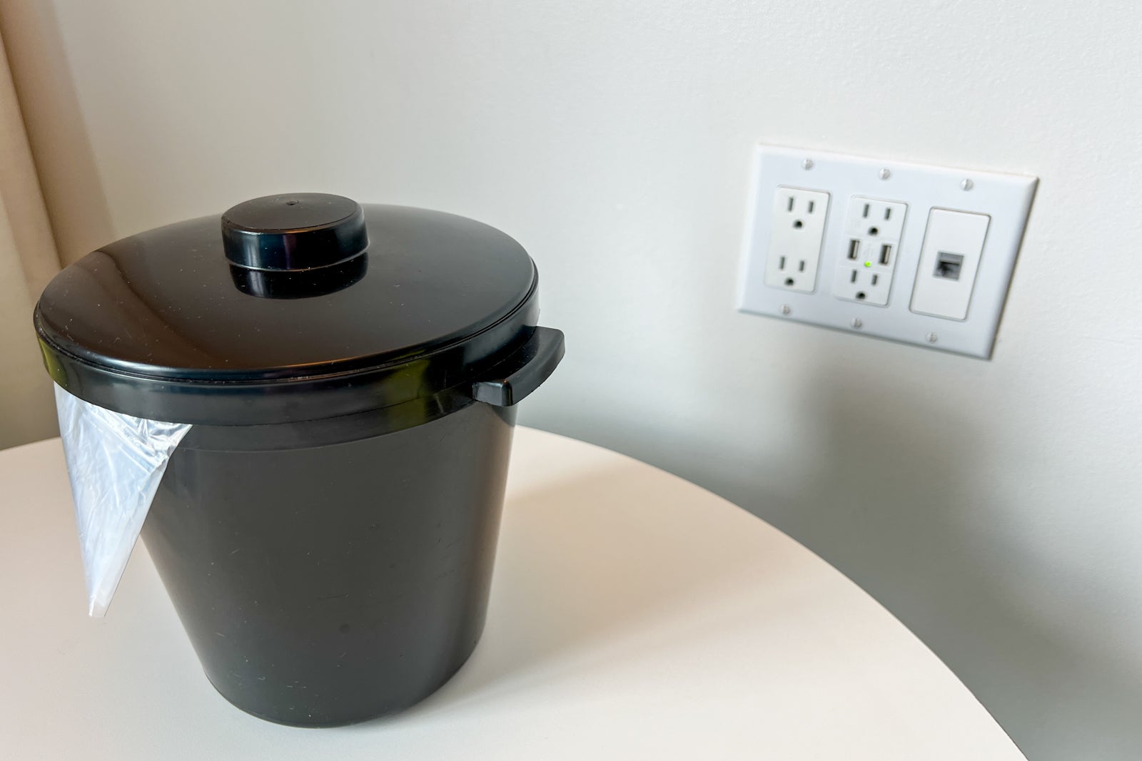 A table with an ice bucket and an outlet with USB plugs.