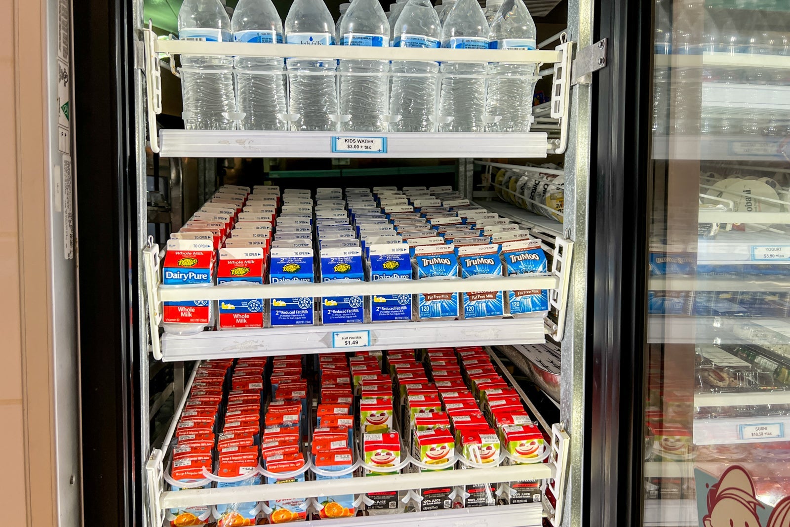 A fridge full of milk, juice and bottled water.