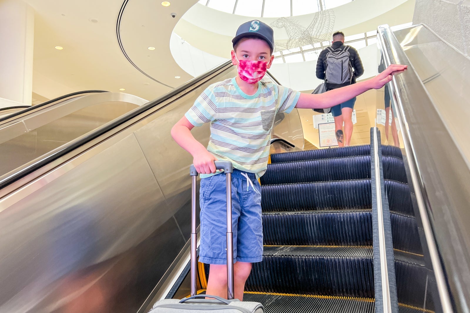 Child on escalator with suitcase
