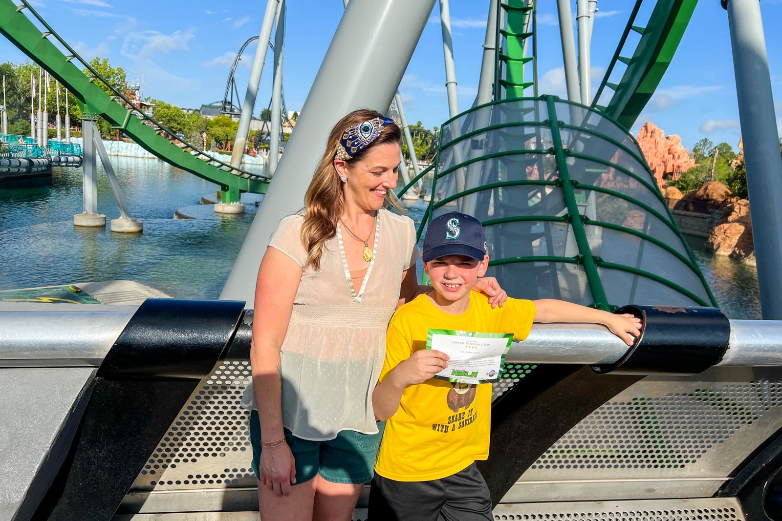 Child and mom standing in front of roller coaster
