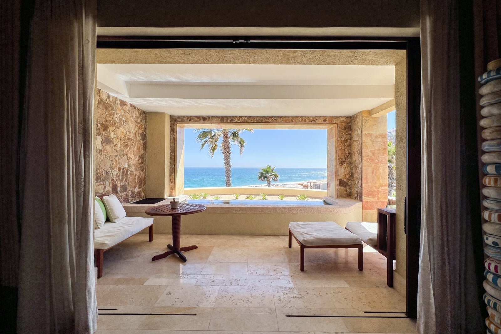 Amex Platinum vs. Business Platinum: Which card is best? looking past a sitting area out an open window to the ocean