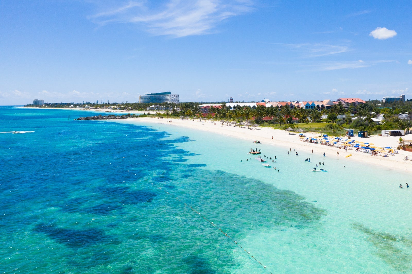 A coastline in the Bahamas with turquoise water, white sand and vegetation