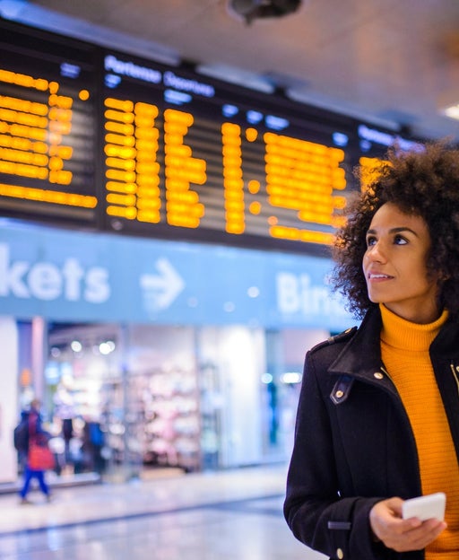 Smiling woman using mobile phone at the airport