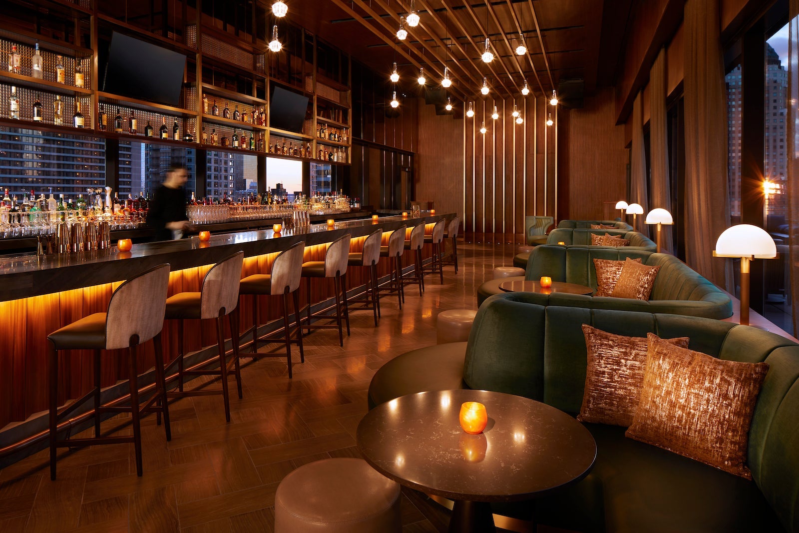 hotel bar with golden lights and green couches