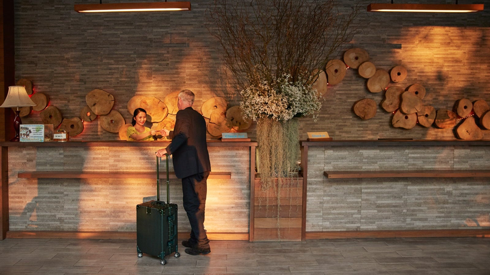 Man giving passport to receptionist in lobby