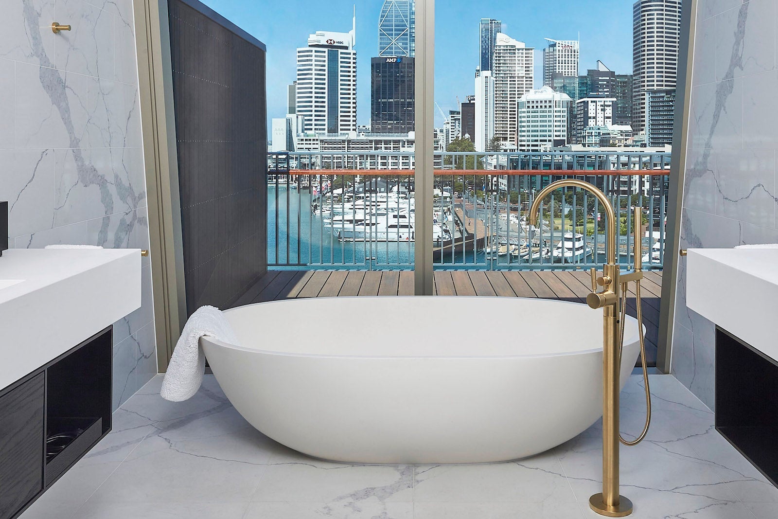 large white bathtub by window looking out on city skyline