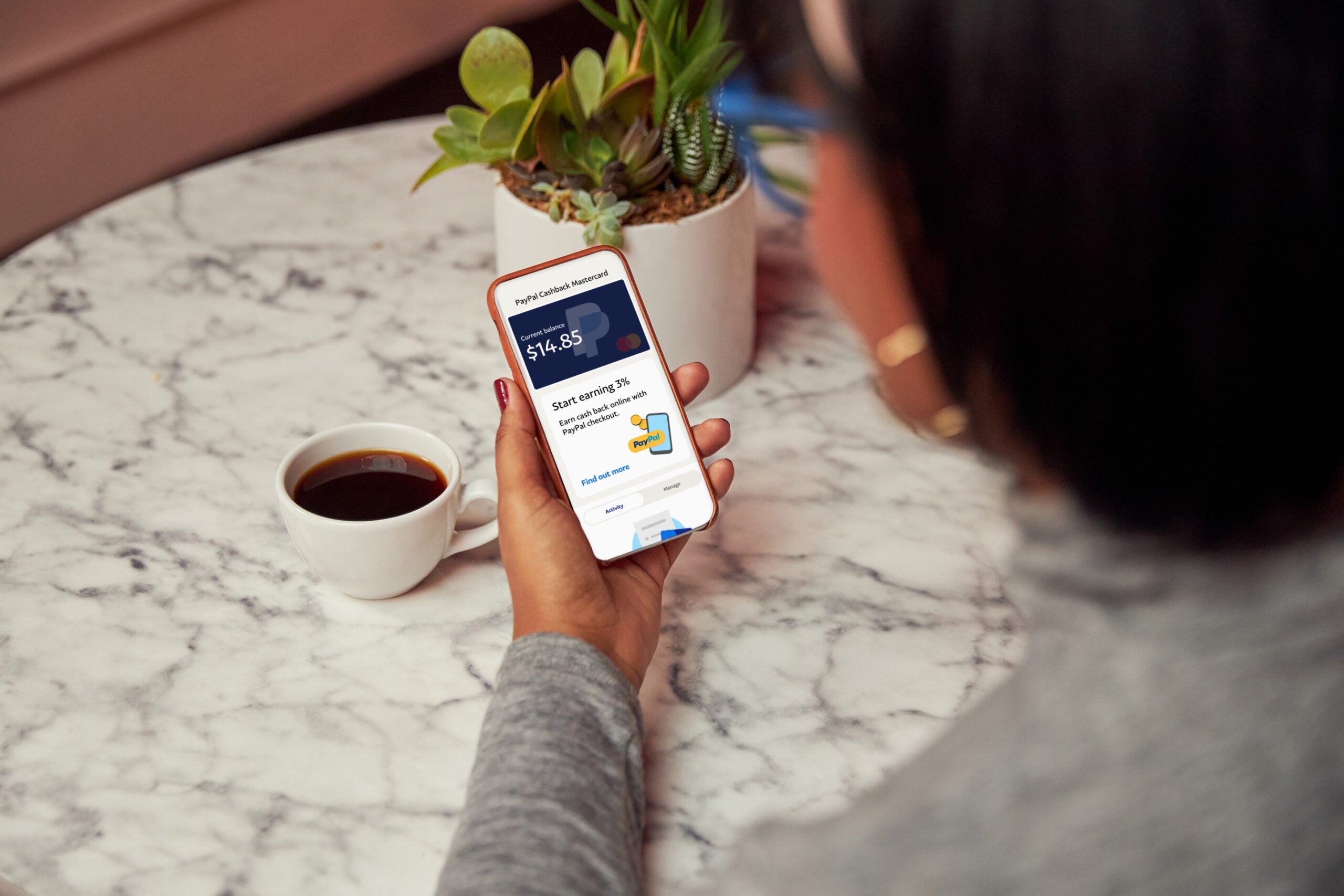 A customer accesses her PayPal Mastercard on her phone