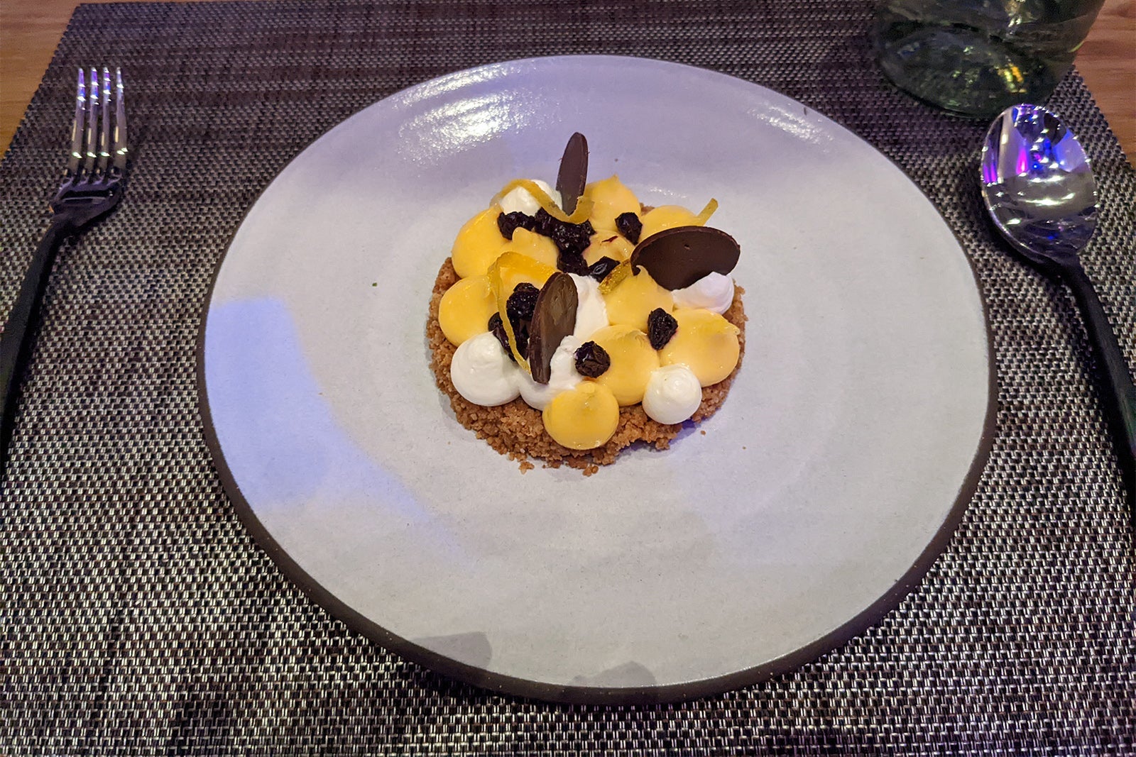 Meyer lemon tart with huckleberries and cream on a graham cracker crust