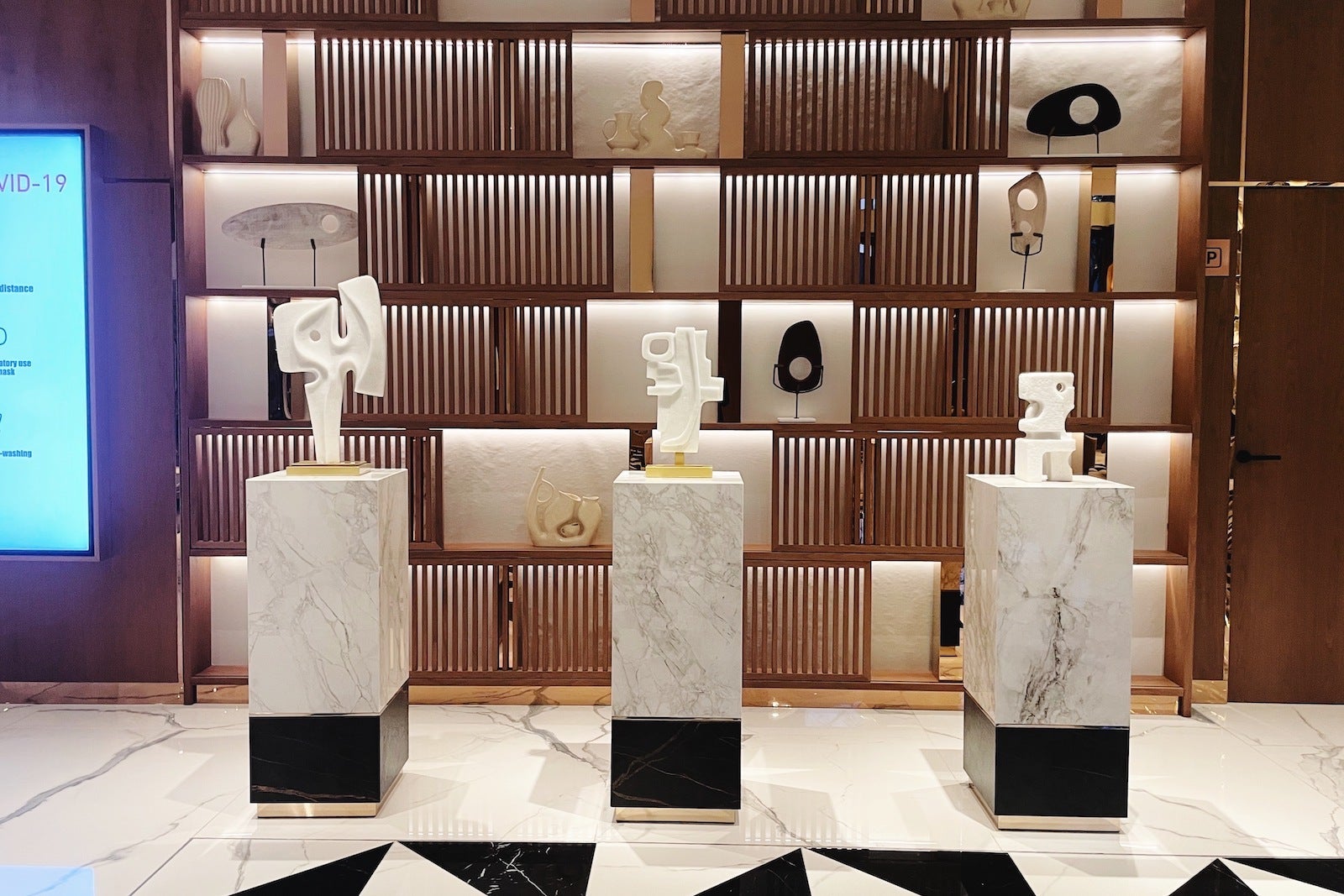 wooden shleves with art behind marble pillars with art