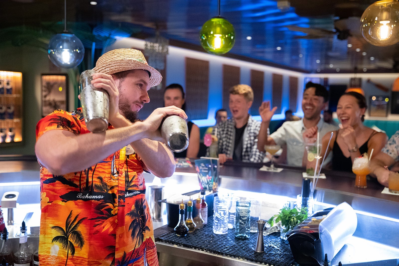 Bartender in Hawaiian shirt making cocktails in shakers