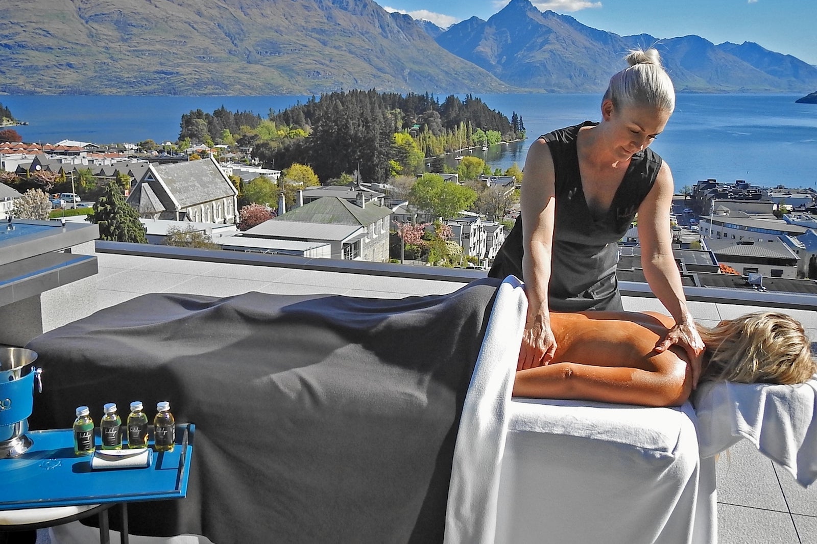 woman getting spa treatment on deck overlooking lake and mountains