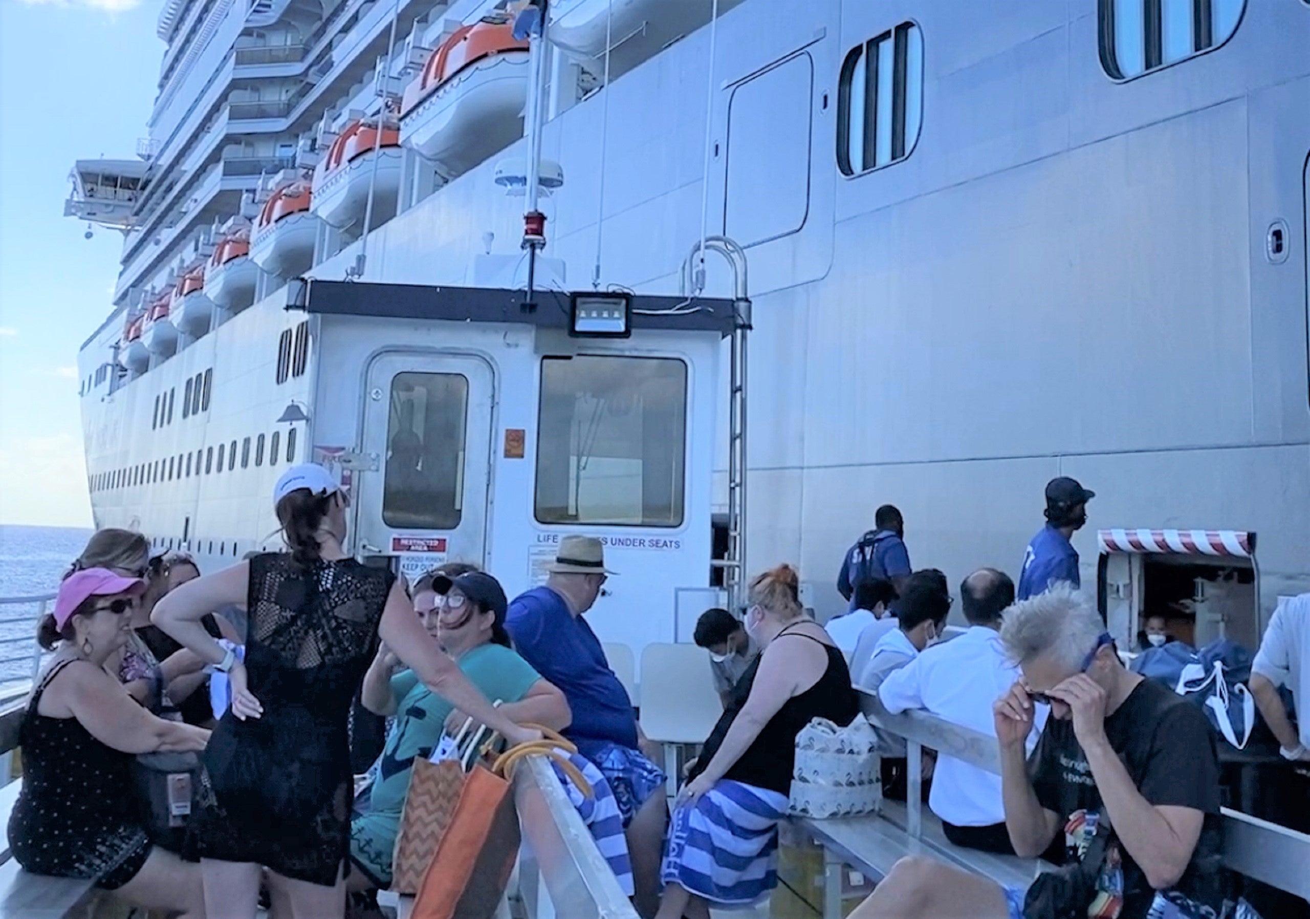 Passengers on a tender boat returning to a cruise ship