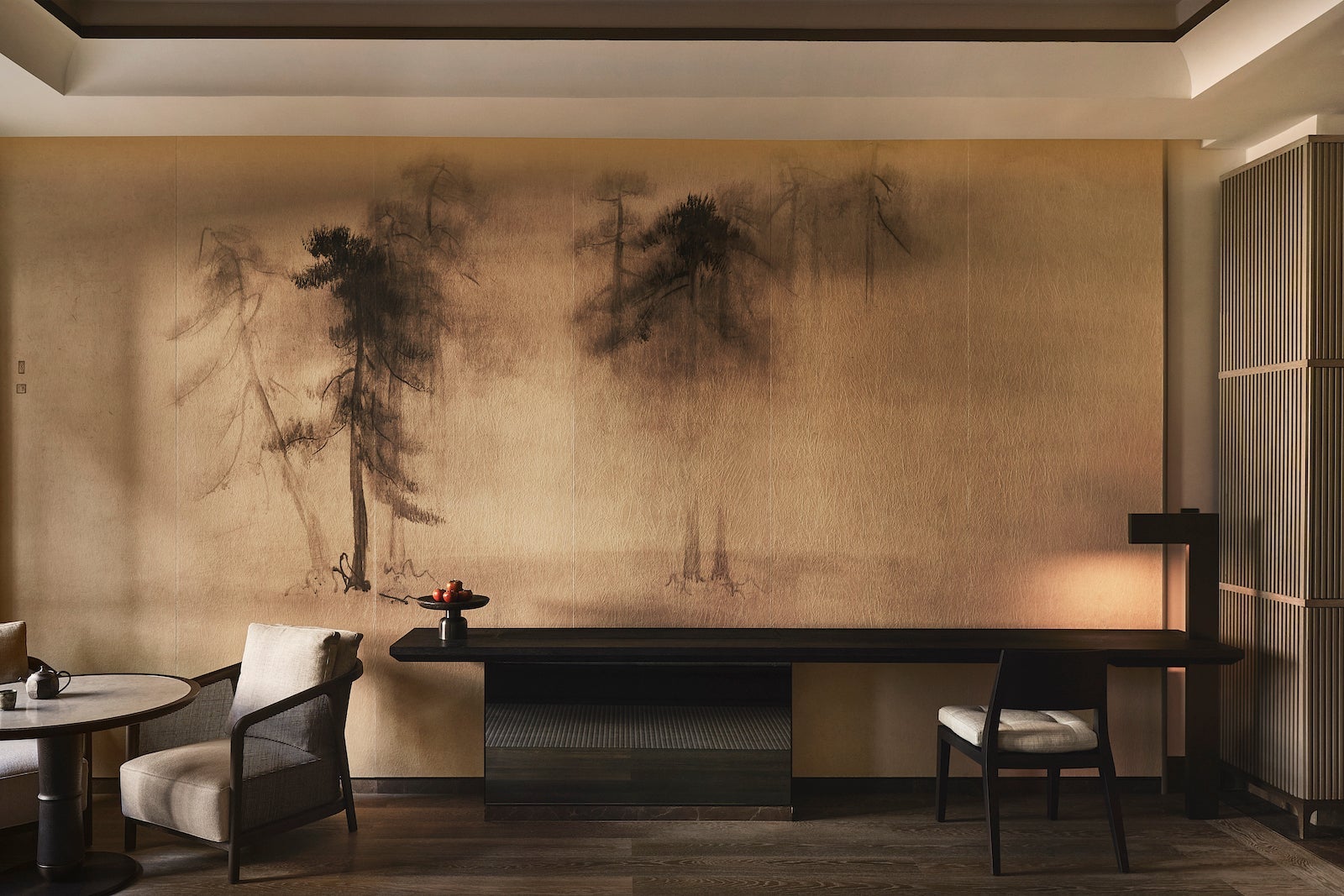hotel room with trees painted on walls, desk with chair