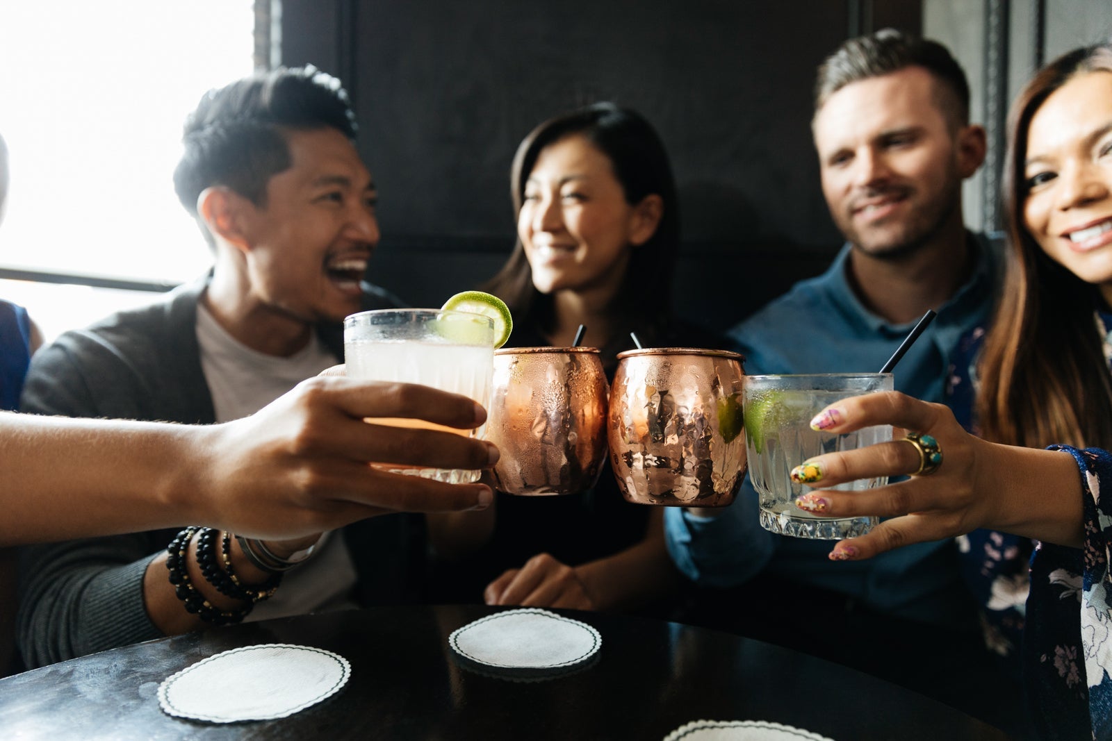 Friends toasting drinks while sitting in restaurant