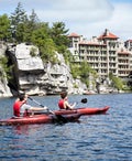 two people kayaking on lake in front of castle resort