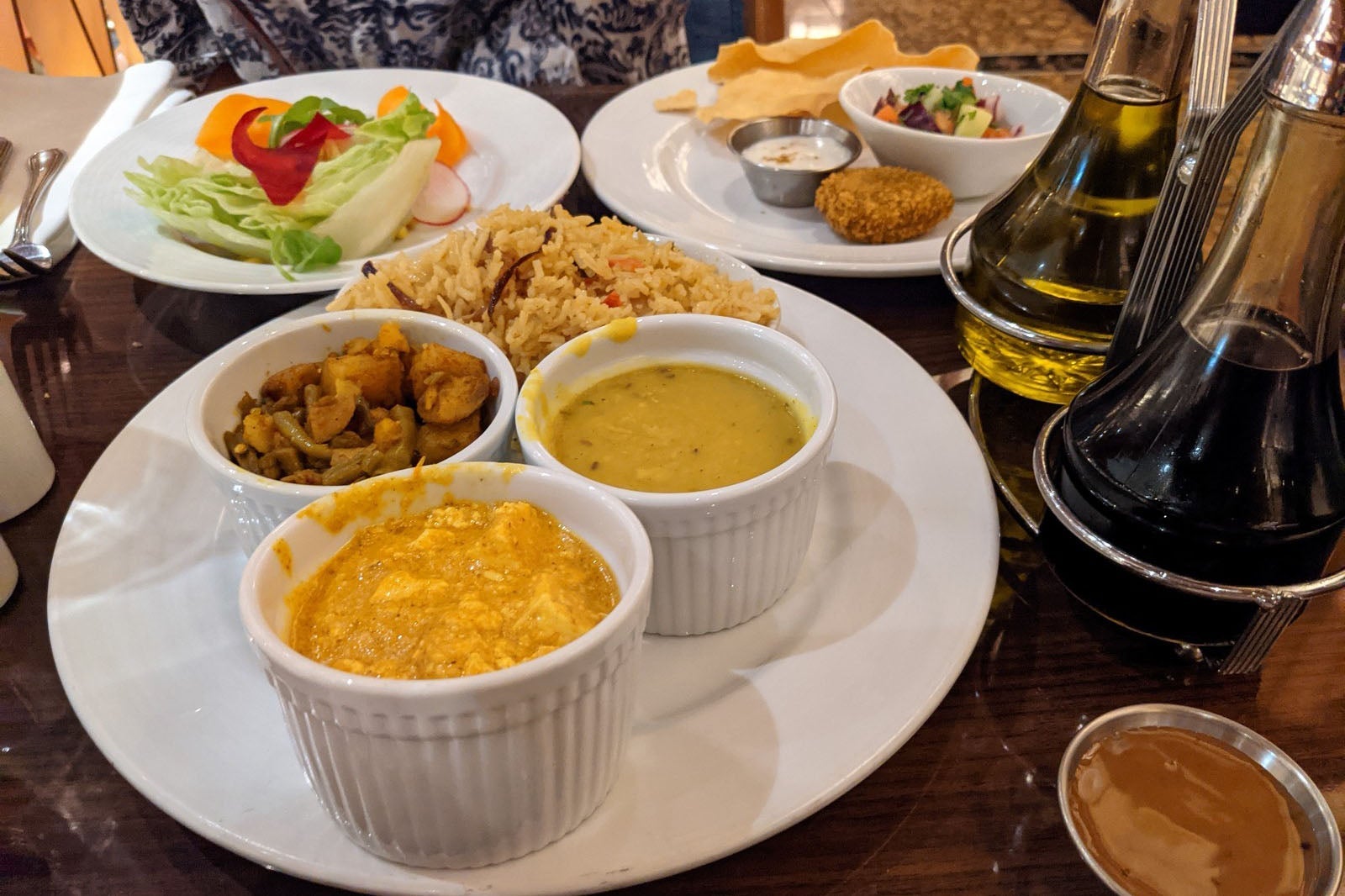 Table filled with white plates of Indian food and salad on cruise ship