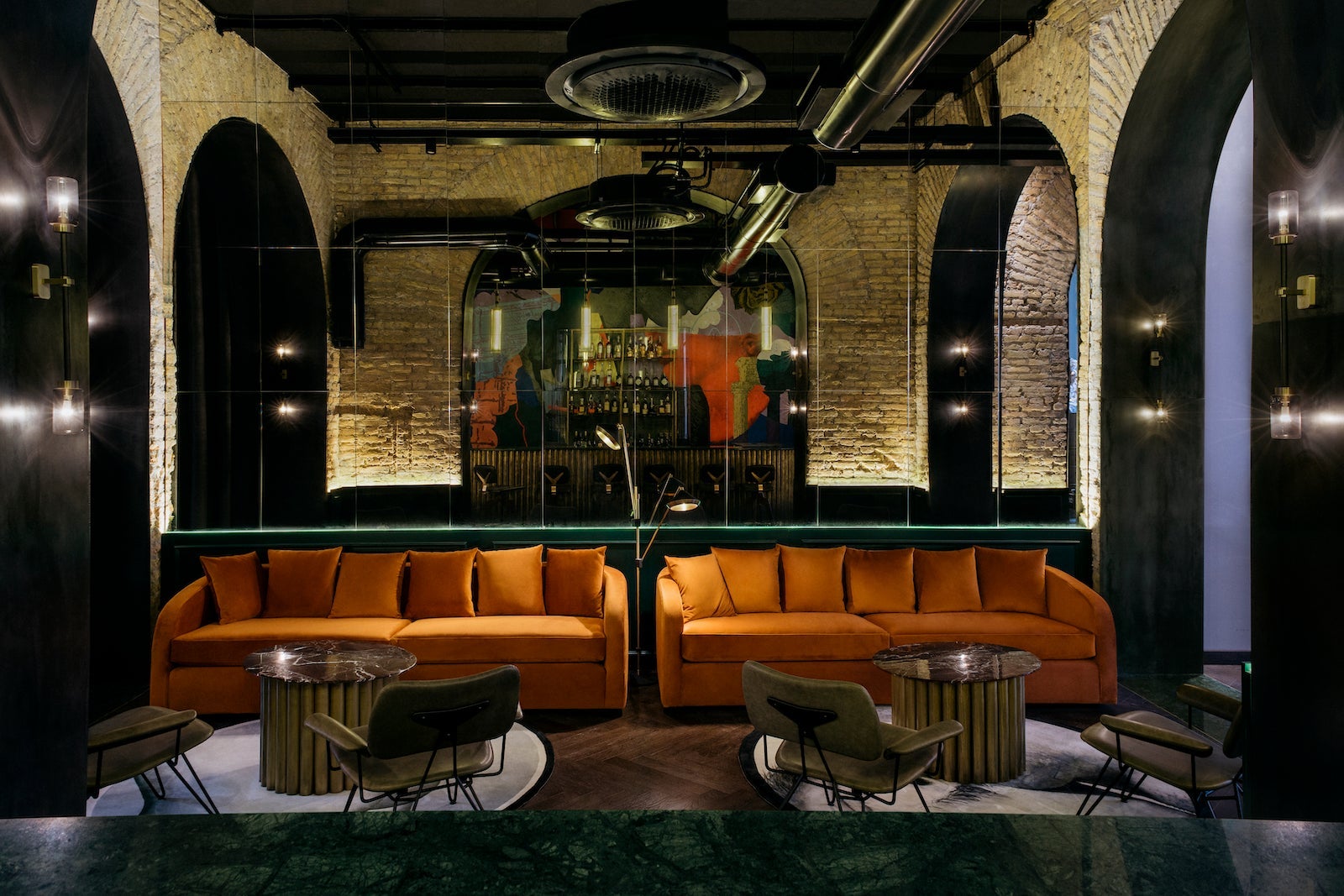 dark hotel bar with orange couches