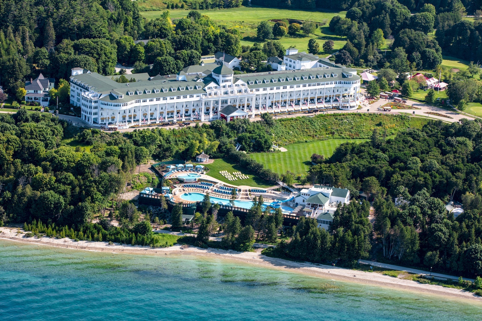 aerial view of large white resort on lake with beach access and waterpark