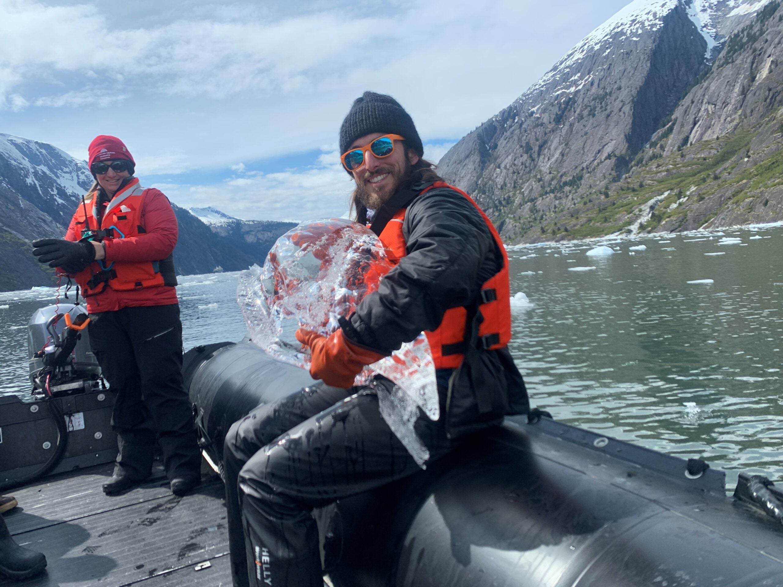 Ocean Victory naturalist holding glacial ice on zodiac.