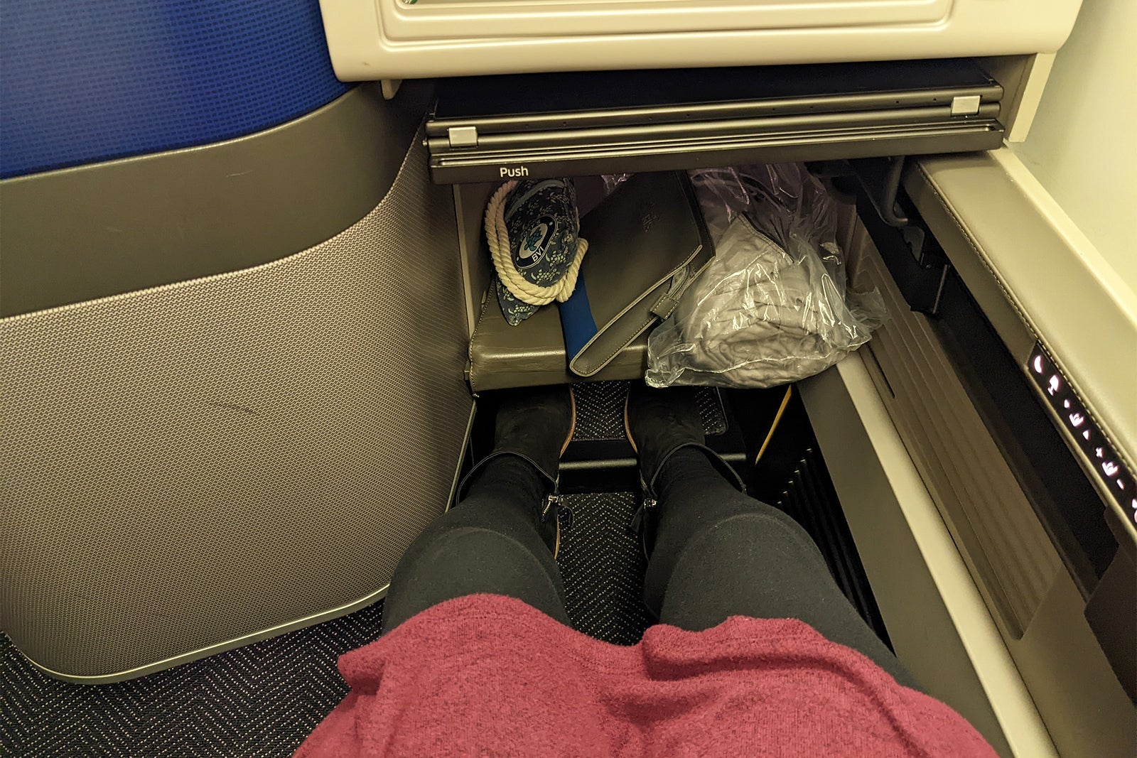 View of my legs and seatwell in United Polaris airplane seat