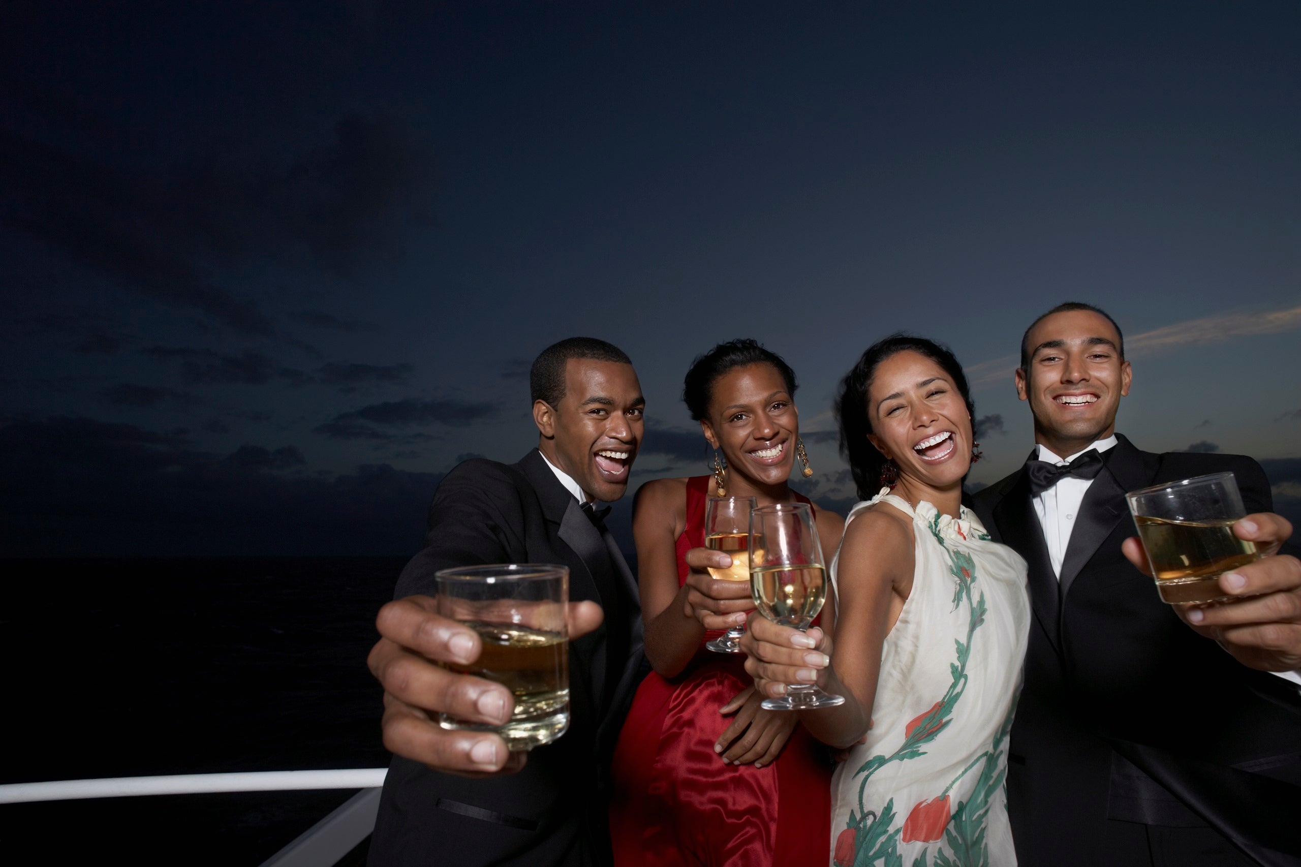 Cruise passengers holding drinks and dressed in formalwear