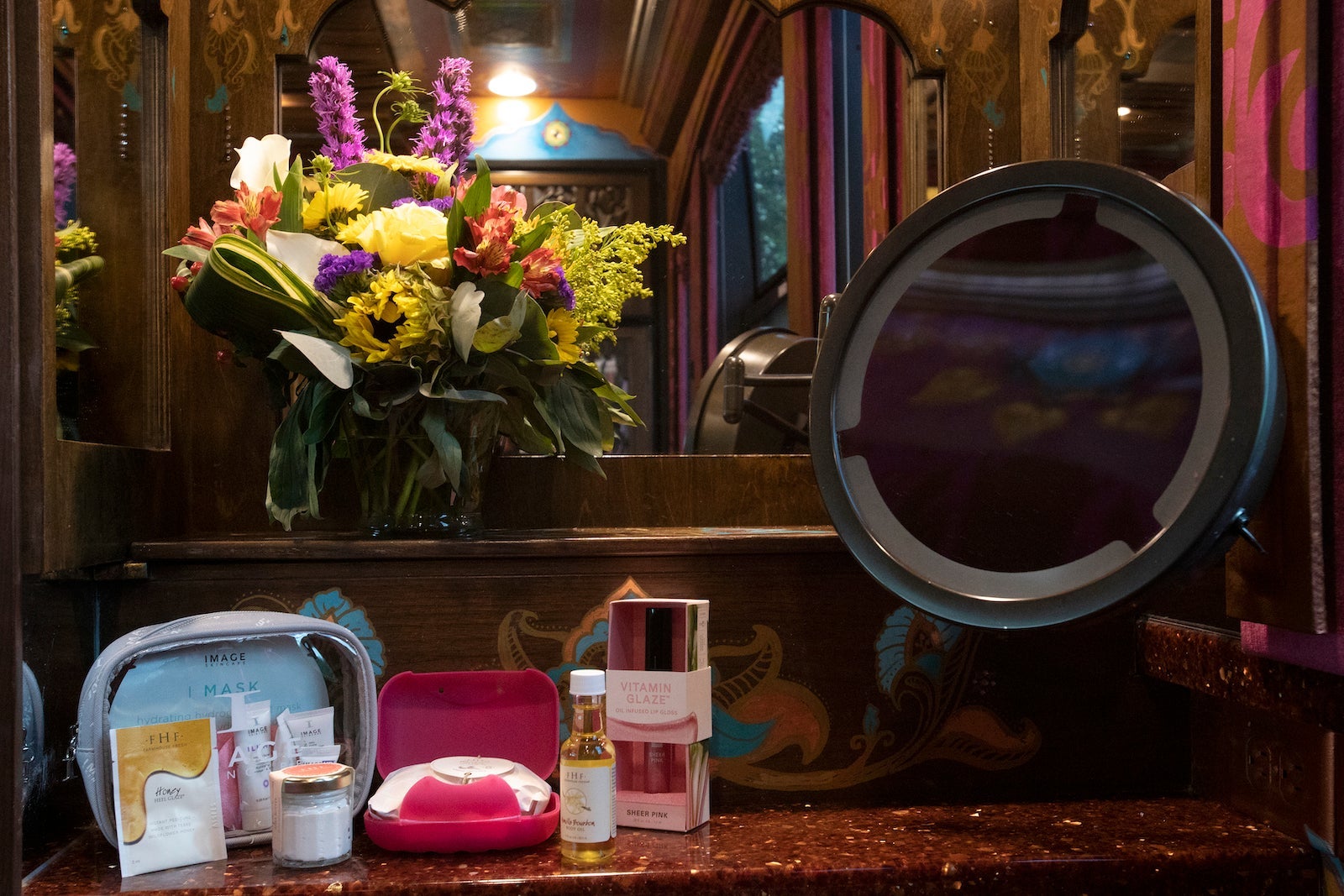 vanity with make up, flowers and mirror