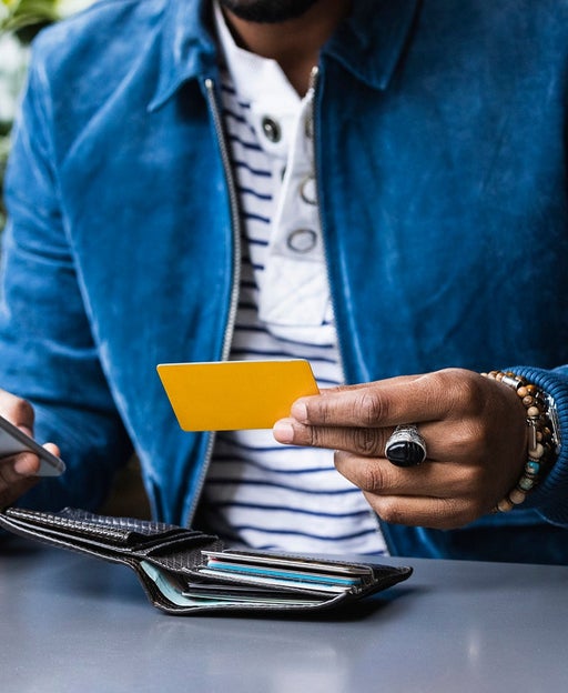 A man holds a credit card while making a phone call